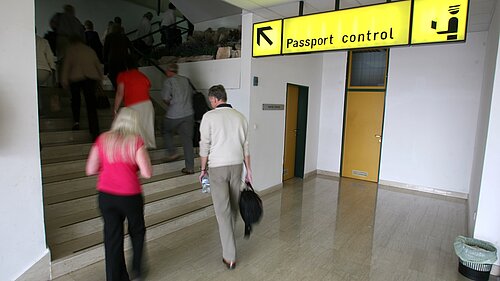 People going up a staircase to passport control.
